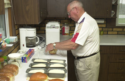 Maria Stein resident Rich Schulze checks out small loaves of bread to be distributed to First Communicants at St. John Catholic Church Sunday afternoon. Baking bread became a unique form of therapy 6 1/2 years ago as he recuperated from a debilitating stroke.<br>dailystandard.com