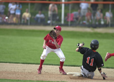 St. Henry's Andrew Huelsman, left, covers second base and awaits the throw from the catcher as Coldwater's Chad Geier, 11, slides in safely for a stolen base. Coldwater stole four bases in the game during the Cavaliers' 12-2, five-inning win over St. Henry in Division III district semifinals action.<br>dailystandard.com