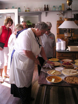 Dru Meyer of New Bremen cuts one of the 21 pies entered in the pie baking contest at the New Bremen Historic Association's sixth annual summer picnic Sunday at the museum.<br>dailystandard.com