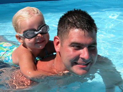 Matt May of Coldwater plays with his 2-year-old daughter Macy in their backyard swimming pool.<br>dailystandard.com