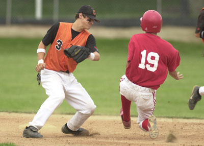 Coldwater's Troy Siefring, 3, tags out St. Henry baserunner Ryan Ranly, 19, during their ACME contest on Tuesday night at Veterans Field. Coldwater defeated St. Henry 6-2 behind a complete game from Matt Howell.<br>dailystandard.com