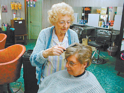 Lois Engle, who has been styling hair for more than 75 years, makes an adjustment in her daughter Becky Davis's curls. The Lois Beauty Shop of St. Marys has been at the corner of High and Front streets in St. Marys for many decades.<br>dailystandard.com