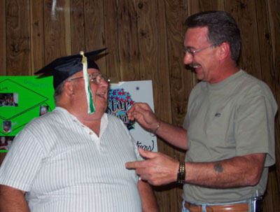 Howard Coats, left, is congratulated by Mercer County Veterans Services Officer Tom Risch during a surprise graduation party held for Coats last week. Coats is one of the first Korean War veterans in the area to receive his high school diploma through a state program aimed at people who dropped out of school to serve in the military.<br>dailystandard.com