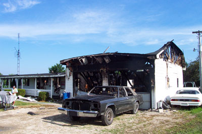 A car awaiting restoration sets in front of a modular home and attached garage destroyed by fire late Monday night. Firefighters from Rockford, Mendon and Chattanooga initially responded to the home of Brandy Vanover and Damien Kroft, 3160 Tama Road, Rockford, and many returned after flames rekindled several times through Tuesday. The loss is set in excess of $75,000.<br>dailystandard.com