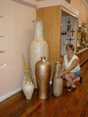 Bonnie Rutschilling, manager of the Potter House on Main Street, makes some adjustments to a display in Celina's newest retail business. The vase in the background is about 6 feet tall and is one of several in the store.<br>dailystandard.com