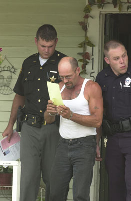 Danny Gates is escorted from his 115 S. Mill St. residence in Celina following a Monday drug bust that netted 12 suspects including his wife and daughter. Shown with Gates are Mercer County Sheriff's Deputy Chris Niekamp, left, and Celina Police Officer Andy Regedanz. <br>dailystandard.com