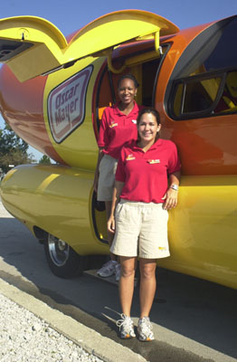 Katie Ryan, foreground, and Kimberly Roth stand at the Oscar Mayer weiner mobile parked on Lake Shore Drive in Celina this morning. The vehicle was in Mercer and Auglaize counties today. See story on page 3A<br>dailystandard.com