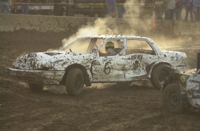 Jim Coats of Celina races in the final lap to win the figure 8 race held Tuesday night at the Mercer County Fair. Several cars raced around a figure 8 track at the same time, often crashing into one another. Coats' car was the first to complete 15 laps to win the feature race. Also held on Tuesday night was the demolition derby for 1977 cars and newer. The last car running to win that show was Pat Browder of Celina. Another demolition derby will be held at 7 p.m. Sunday in front of the grandstand.<br>dailystandard.com