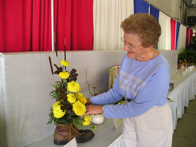 Eileen Bollenbacher, Rockford, arranges some marigolds for her Old Woman in the Shoe entry in the flower show at the Mercer County Fair on Friday. The fair continues this weekend and ends Monday with the Junior Fair livestock auction.<br>dailystandard.com