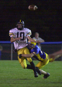 Parkway's David Bell, 10, gets hit as he throws the ball by a Marion Local defensive player. Marion Local's defense held Parkway in check for the night, winning the game, 28-6.<br>dailystandard.com