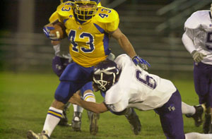 Fort Recovery's Greg Faller, 6, tries to stop St. John's running back Matt Shumaker during Saturday's game in Delphos.<br>dailystandard.com