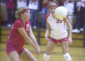 St. Henry's Kyle Elking, left, passes the ball to a teammate as Christa Schwartz, right, looks on during Division IV regional semifinal action at Vandalia-Butler High School. St. Henry survived a scare from Jackson Center, 25-21, 25-19, 22-25, 25-14.<br>dailystandard.com