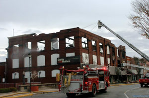 Fire crews are shown on the scene of the Oct. 31 fire that struck the Glass block building on Spring Street in downtown St. Marys. Parking remains restricted and traffic is maintained in narrow lanes as officials worry about the integrity of the structure.<br>dailystandard.com