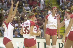 St. Henry's Danielle Everman, left, Christa Schwartz, 35, Kayla Lefeld, 15, and Lindsey Thobe, 21,  celebrate their Division IV state semifinal win over Kalida on Friday night. St. Henry defeated Kalida in three games and will play Norwalk St. Paul for the state title today at 4 p.m.<br>dailystandard.com