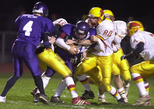 New Bremen's Jake Schlater, 80, and Alex Leugers, 12, combine to tackle a Mechanicsburg runner during their game on Friday night.<br>dailystandard.com