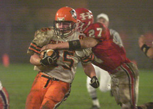 Coldwater's Ross Homan, 25, tries to break a tackle against Huron during Friday's Division IV regional final game at Fostoria. Coldwater won the game, 19-6.<br>dailystandard.com