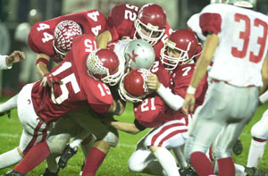 A mass of Redskin defenders, led by Ryan Hartke, 15, Ross Niekamp, 44, Kalen Hemmelgarn, 52, and Josh Werling, 21, swarm an East Clinton ballcarrier.<br>dailystandard.com