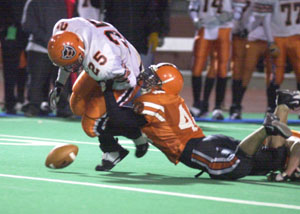Coldwater's Ross Homan, 25, gets stripped of the ball by  Versailles' Alex Davis during Friday's Division IV state semifinal at Dayton's Welcome Stadium. Versailles' defense and running game on offense prevailed in a 14-0 Tigers win.<br>dailystandard.com