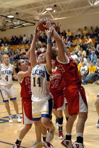 Marion Local's Maria Moeller, 14, battles with St. Henry's Brenda Hemmelgarn, right,  and Kayla Lefeld, left, for a rebound during their game on Thursday night.<br>dailystandard.com