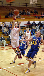 St. Henry's Lanee Mikesell, 15, goes up high for a layup as St. Marys defenders Toya Anderson, 3, and Brittany Howell watch.<br>dailystandard.com