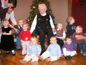 Bernie Homan of St. Henry is surrounded by nine of her 10-great-grandchildren who all are 1-year-old this Christmas. The children share the same age during a 14-day period from Dec. 17 through Dec. 30. Homan, the mother of nine children, is blessed with a total of 31 grandchildren and 24 great-grandchildren. The tenth great-grandchild, Kylie Jo Fortkamp, pictured below, was absent from the party.<br>dailystandard.com