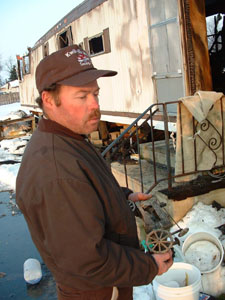Kevin John, 8361 Deep Cut Road, Mendon, displays a toy John Deere tractor he pulled from the ashes of his charred home this morning. John lost everything with the exception of two pairs of boots and a coat that he left inside his pickup truck.<br>dailystandard.com