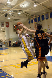 St. Marys' Wes Clark, gets his shot blocked by Minster's Justin Spillers during Tuesday's game at McBroom Gym.<br>dailystandard.com