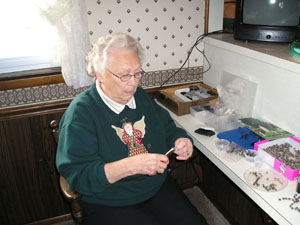 Cam Wenning of Coldwater makes a rosary from small Coix lacryma-jobi seeds.<br>dailystandard.com