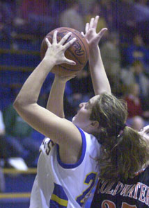 St. Marys' Stephanie Platt, 21, puts up a shot over the outstretched arm of Coldwater's Jessica Bettinger, 25.<br>dailystandard.com