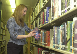 Celina librarian Elizabeth Muether puts a book back on a shelf in the library. Several local government officials and librarians met in Sidney on Monday evening to lobby against proposed funding cuts.<br>dailystandard.com