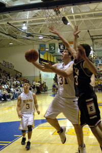 St. Marys' Todd Graves, 31, tries a reverse layup around Elida's Aaron Thompson, right, during their Western Buckeye League matchup on Friday night at McBroom Gymnasium. St. Marys defeated Elida, 34-31, to stay atop the league standings with Celina and Van Wert.<br>dailystandard.com