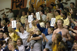 Marion fans hold up cards signifying Flyer junior Maria Moeller reaching the 1,000-point mark of her career during Thursday's MAC finale with New Knoxville.<br>dailystandard.com