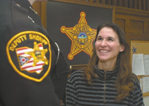 Tricia Christian shares a warm smile and words of support with a Mercer County Sheriff's deputy. She also responds to calls made on behalf of female inmates as part of a chaplaincy program established two years ago at the sheriff's office and jail.<br>dailystandard.com