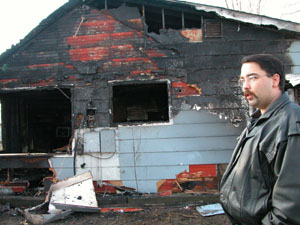 Montezuma firefighter Jeff White stands near the home of neighbor William 