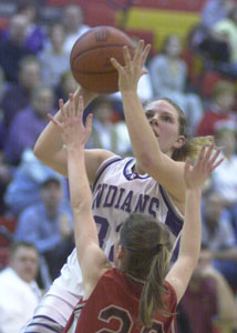 Fort Recovery's Holly Stein, with ball, tries to shoot over New Knoxville's Haley Kruse, 22, during their Division IV sectional semifinal contest on Tuesday at New Bremen. Fort Recovery defeated New Knoxville, 45-31.<br>dailystandard.com