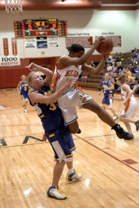 St. Marys' Brittany Howell, left, takes the contact as Elida's Carla Warren comes down with the rebound during Wednesday's game.<br>dailystandard.com
