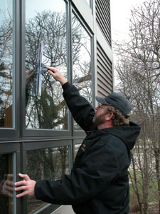 Glass is left sparkling when cleaned with a squeegee instead of a cloth that can leave lint and subtle streaks, says professional window cleaner Ron Adams while working at a customer's home on the east side of Grand Lake St. Marys. Adams owns Adams Window Washing of New Bremen.<br>dailystandard.com