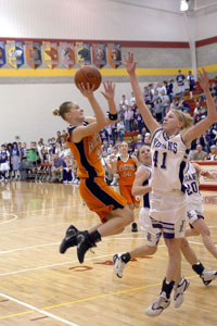 Minster's Karen Brackman, 22, flies to the hoop as Fort Recovery's Tiffany Gaerke tries to block the shot.<br>dailystandard.com