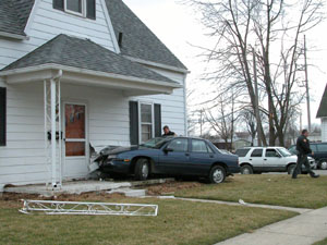 A police officer checks the scene of an accident after a car driven by a 15-year-old Celina boy crashed into a house at the corner of Clinton and South Perry streets in St. Marys. The accident occurred following a high-speed pursuit through parts of Mercer and Auglaize counties with speeds reaching 109 miles per hour.<br>dailystandard.com