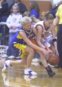 Marion Local's Holly Fortkamp, left, and Minster's Karen Brackman, right, fight for a loose ball during the Division IV district final contest at Coldwater High School on Saturday. Marion Local defeated Minster, 68-48.<br>dailystandard.com