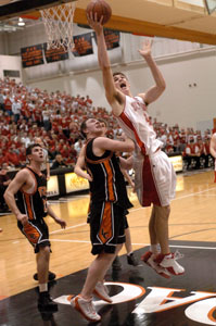 St. Henry's Kurt Huelsman, right, scores two of his team-high 15 points as Liberty Center's Andrew Quigley tries to defend during their Division III district semifinal game at Ohio Northern University. St. Henry defeated Liberty Center, 50-29.<br>dailystandard.com