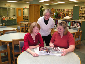 The Celina High School yearbook recently received top honors. At right are editor Lindsey Puthoff, right, with advisers Connie Opperman and Amy  Sutter, reviewing a 2004 copy of the Anilec yearbook.<br>dailystandard.com