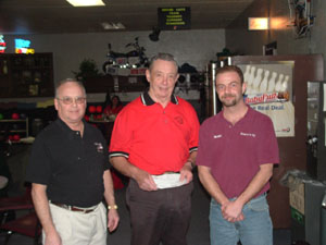 Bud Gray, center, holds the checks totaling $1,000 that he was awarded after bowling a 300 game at Plaza Lanes in Celina. Gray, an 84-year-old, is joined on the left by Plaza Lanes owner Ron Cisco and on the right is Scott Fowler from Fowler's TV in St. Marys.<br>dailystandard.com
