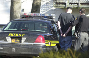 Celina resident Darin Miller gets into a Mercer County Sheriff's Office cruiser under the watchful eye of Deputy Brian Kellermeyer. Miller is one of 24 people facing nearly 60 felony drug charges. Three suspects remain at large but Sheriff Jeff Grey hopes they will be in custody by the time he conducts a 2:15 p.m. press conference today. A Mercer County grand jury handed down the indictments last week.<br>dailystandard.com