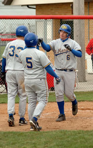 St. Marys' Todd Graves, 6, is congratulated by teammates Deron Steinke, 33, and Kyle Cheslock, 5, after Graves hit the second of his two home runs in the Roughriders' 13-0 win over St. Henry.<br>dailystandard.com