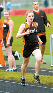 Minster's Jenna Fausey runs a leg of the 3,200-meter relay. Fausey helped the Wildcats finish first in the race.<br>dailystandard.com