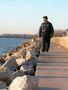 Celina Police Sgt. Tom Wale scans the West Bank shoreline of Grand Lake early this morning as part of an ongoing search for the bodies of two Celina High School freshmen presumed drowned last weekend. See photo on page 3A.<br>dailystandard.com