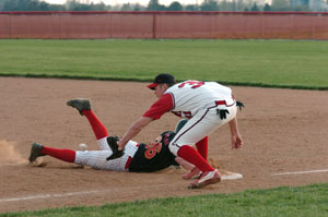 New Bremen's Aaron Timmerman, 36, slides back into first as St. Henry first baseman Alan Hartke reaches for the ball.<br>dailystandard.com