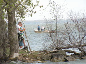 Jordan Rolfes, left, and Josh Houts keep a vigil at Harbor Point where rescuers recovered the body of their friend, Celina High School freshman Greg Parker on Wednesday afternoon. Less than three hours later, the body of their other friend and classmate, Jonas Kahlig, was found about a half-mile away. The boys apparently drowned while trying to make their way across Grand Lake in a small boat 12 days ago.<br>dailystandard.com