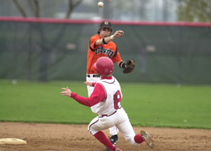 Coldwater's Chad Geier throws the ball to first as St. Henry's Michael Gast, 8, slides in during Friday's MAC battle between the Cavaliers and Redskins at St. Henry.<br>dailystandard.com